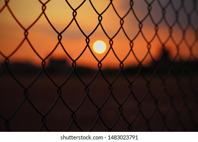 Close up of a fence with blurred sunset background - Powered by Shutterstock