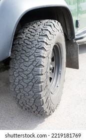 Close Up Of Fender Of Green Edged All Terrain Car With Chunky Solid Cross Country Four Wheel Drive Tire Turned To Camera As Concept For Outdoor 4x4 4wd Off Road