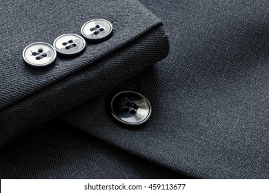 Close up of a few buttons on a business suit coat