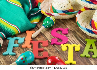 Close Up Of Fiesta Table With Colorful Wooden Fiesta Maracas, Sombreros And Traditional Table Runner.