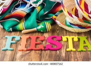 Close Up Of Fiesta Table With Colorful Wooden Fiesta Maracas, Sombreros And Traditional Table Runner.