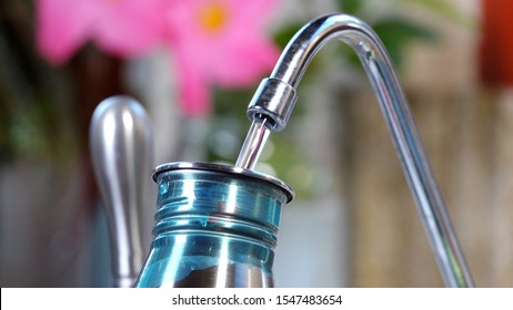 Close Up Filling Reusable Metal Water Bottle At Reverse Osmosis Faucet - No Need For Disposable Plastic