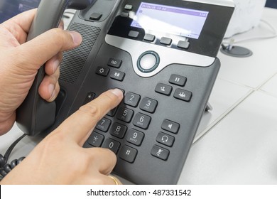 Close Up Of Finger Dialing To Make A Phone Call In Office