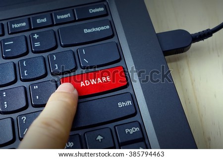 Close up of finger on keyboard button with ADWARE word