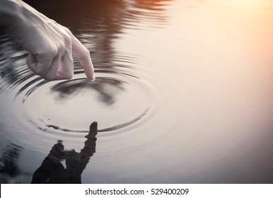 Close Up Finger Touches Water And Drop Of Water Falling And Creating Natural And Calm Waves,calmly Concept,