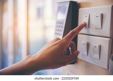 Close up of finger turn off on light switch at the wall. Energy saving concept. Selected focus - Shutterstock ID 2233329769