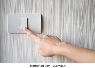 Close up of finger is turning on or off on light switch. Copy space.