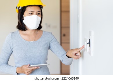 Close Up Of Fingers Asian Women Home Inspection Pointing To  Switch Wearing Vests And Hard Hat At New Property