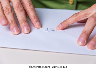 Close Up Of Fingers Folding A Paper