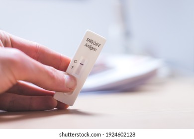 Close up of fingers holding express antigen covid test, negative result - Shutterstock ID 1924602128