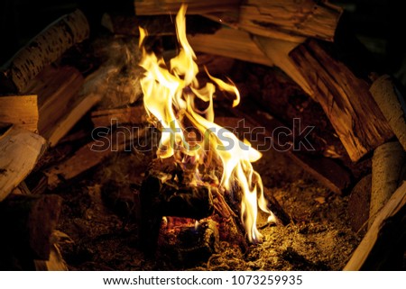 Close up at the fire. Vintage fireplace for cooking food inside the old wooden viking longhouse in the reconstruction of ancient village. Interior of viking house.