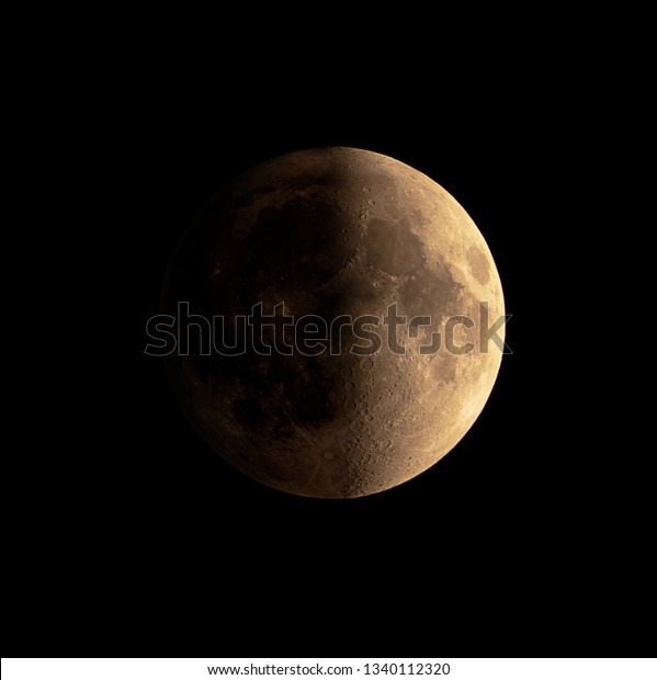 Close up of First quater Moon phase with detail in\
shadow on dark sky