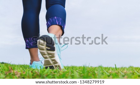 Close up of fitness woman athlete's running shoes while walking in the park outdoor. Sport, healthy, wellness and active lifestyle background concepts with copy space.