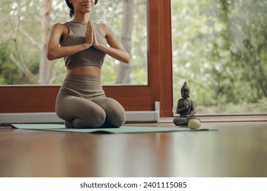 Close up of fitness woman meditate while doing yoga indoors at home on mat - Powered by Shutterstock