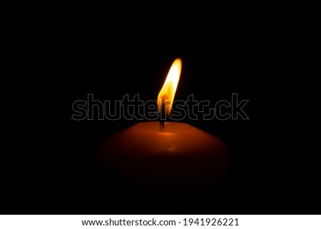 Close up flame of burning candle on black background sorrow remembrance day concept 