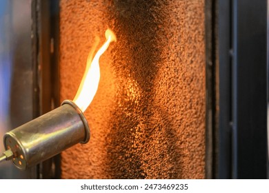 Close up of a flame torch testing flame retardant material, demonstrating fire resistance and safety - Powered by Shutterstock