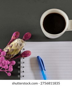 Close Up Flat Lay Note Pad And Pen Cup Of Coffee With Interesting Purple Bunch Of Flowers Portrait Orientation Blank Background With Copy Space