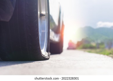 Close Up Of Flat Rear Tire Of Black Suv Car Vehicle Automobile Punctured By Nail. Summer Day, Residential Street. Selective Focus, Depth Of Field, Space For Copy. Bad Luck, Accident Concept.