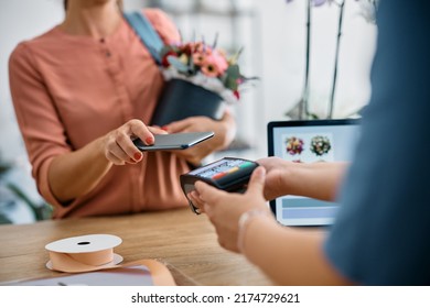 Close Up Of Flower Shop Customer Playing Contactless With Her Smart Phone.