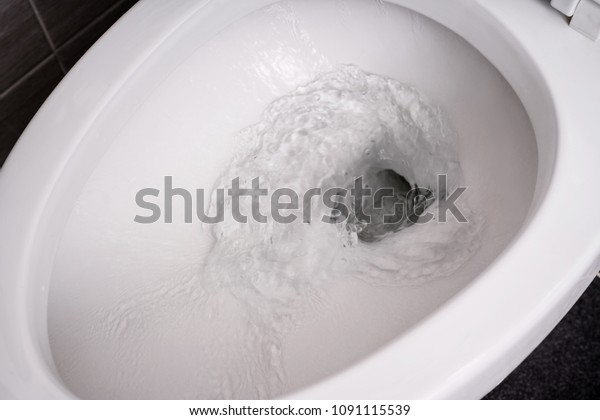 close up flushing water\
in toilet bowl.