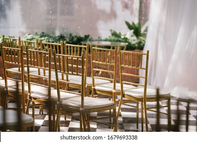 Close up fo the golden Tiffany chairs in the indoor farden wedding setup 