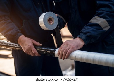 Close Up Focus Hand View Of Professional Industrial Workers Bonding Meta Pipe With Duct Tape.