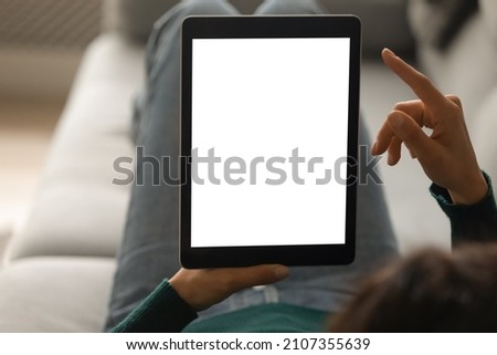 Close up focus on digital computer touchscreen tablet with mock up white empty screen in female hands, copyspace for advertising shopping or entertaining software app, modern tech addiction concept.