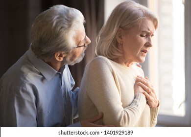 Close Up Focus On Elderly Wife Hold Hand On Breast Touch Chest Having Heart Attack Feels Unwell, Worried Husband Supporting Her, Myocardial Infarction Symptoms, Immediately Emergency Call Need Concept