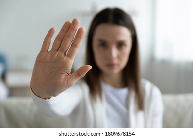 Close up focus on female hand showing stop gesture, protesting against domestic abuses or violence. Decisive woman saying no to abortion, denying gender discrimination, nonverbal language concept.