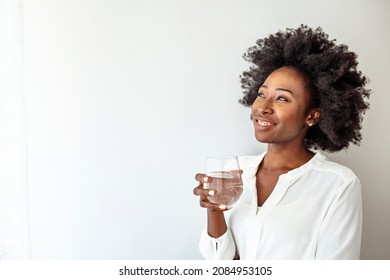 Close up focus on female holding glass african woman drinking still water having thirst healthy lifestyle body skin care hydration aqua balance regulation concept, studio shot on grey background