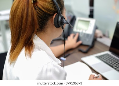 close up focus on headphone of asian call centre response answer or use telephone working in operation room concept.