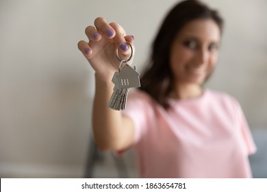 Close up focus on keys with cute house shape keychain in female hands, smiling mixed race arabic homeowner celebrating moving into new apartment, making bank mortgage credit deal real estate concept. - Shutterstock ID 1863654781