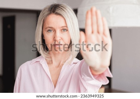 Close up focus on middle-aged woman hand showing stop gesture, strong adult female protesting against domestic violence and abuse, bullying, saying no to gender discrimination

