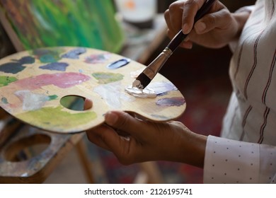 Close up focus on palette with mixed paints, motivated young professional artist drawing new artwork on canvas, creating colors, improving craft skills or enjoying master class in gallery or studio. - Powered by Shutterstock