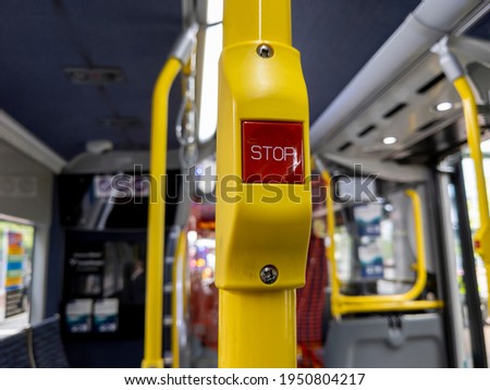 Close up focus on a red 'Stop' button inside a metro bus in Seattle, WA