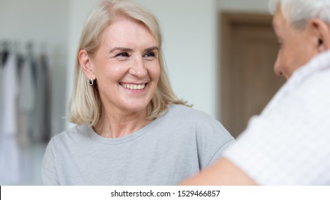 Close Up Focus On Smiling 50s Or 60s Woman Communicates With Old Man, Adult Daughter And Elderly Father Or Caregiver Assisting Patient Listening Him Having Good Relationships, Nursing Services Concept