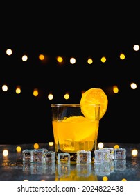 Close Up Focus At Orange Juice With Slice Fresh Orange On Glass Rim, Behind Ice On Table With Light Background, Bartender Prepare Fruit Cocktail Or Fresh Juice For Drinking In Party At Bar