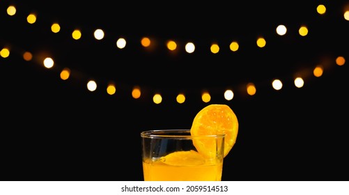 Close Up Focus At Orange Juice With Slice Fresh Orange On Glass Rim, Behind Ice On Table With Light Background, Bartender Prepare Fruit Cocktail Or Fresh Juice For Drinking In Party At Bar