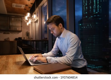 Close Up Focused Businessman Using Laptop In Office At Night Alone, Looking At Screen, Typing, Serious Entrepreneur Employee Finishing, Working On Online Project At Late Hours, Deadline Concept