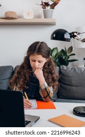 Close Up Of Focused Little Girl Child Writing Notes Study With Laptop And Books, Serious Small Kid Doing School Tasks At Home, Writing Notes, Listening To Lecture Or Music, Distance Education Concept