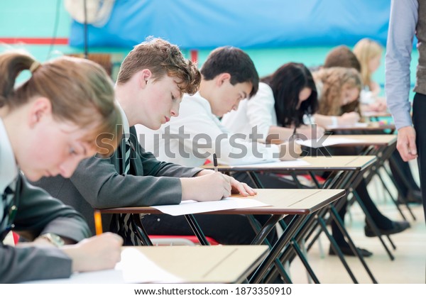 Close up of focused middle school students taking\
examination at desks