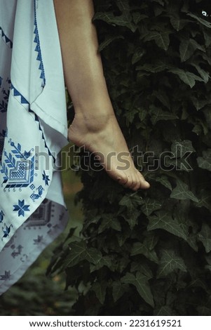 Close up foot and climbing ivy concept photo. Conceptual style. Side view photography with green forest on background. High quality picture for wallpaper, travel blog, magazine, article