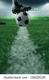 Close up of foot on top of soccer ball on the line