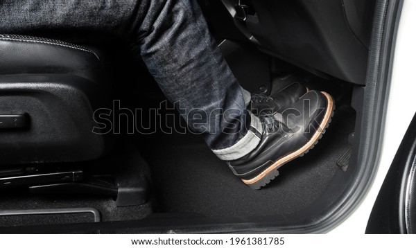 Close up the foot pressing foot pedal of a car to\
drive. Accelerator and brake pedal in a car. Driver driving the car\
by pushing accelerator and break pedals of the car. inside vehicle.\
control pedal.