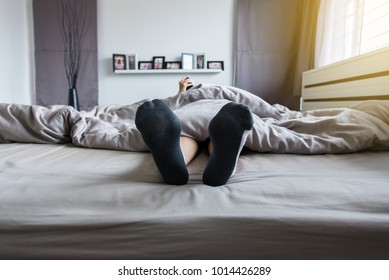 Close Up Of Foot With Socks,Feet On The Bed After Waking Up