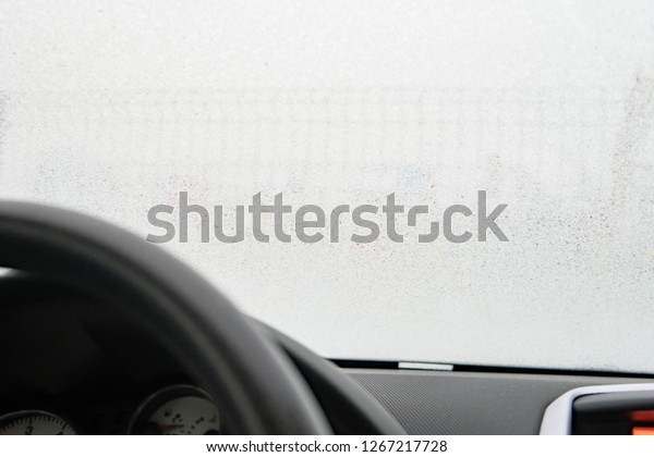 Close up footage of a car windshield, frost on\
the windshield of the car. View from the driver\'s side. a frozen\
car windshield
