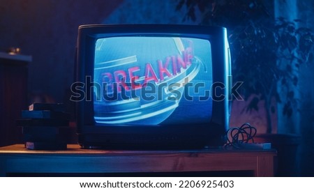 Close Up Footage of a Dated TV Screen. Breaking News Report Starting. Intro with Word Breaking Revolving Around Digital Earth on Vintage Display. Nostalgic Retro Nineties Technology Concept.