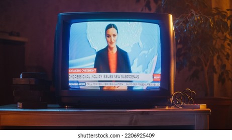 Close Up Footage Of A Dated TV Set Screen With Breaking News Report. Beautiful Female Host Reads Important News On Live Television Broadcast. Nostalgic Retro Nineties Technology Concept.