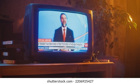 Close Up Footage Of A Dated TV Set Screen With Breaking News Report. Handsome Middle Aged Anchorman Reads Important News On Live Television Broadcast. Nostalgic Retro Nineties Technology Concept.