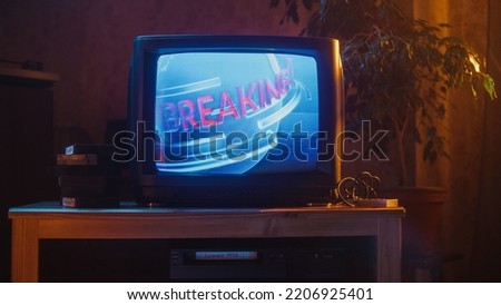 Close Up Footage of a Dated TV Set Screen. Breaking News Report Starting. Intro with Word Breaking Revolving Around Digital Earth on Vintage Display. Nostalgic Retro Nineties Technology Concept.